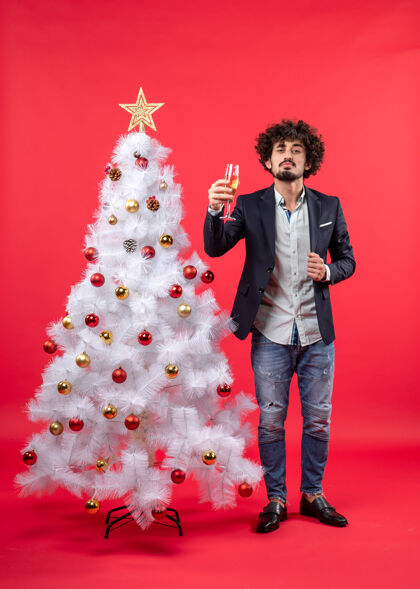 礼物圣诞树旁站着一位满脸胡须 带着美酒的骄傲年轻人 庆祝圣诞节葡萄酒时尚装饰