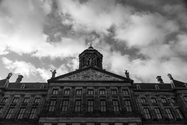 城市荷兰阿姆斯特丹大坝广场皇宫的低角度灰阶照片老荷兰荷兰