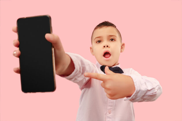 青少年室内肖像的迷人的年轻男孩拿着空白的智能手机电话智能电话