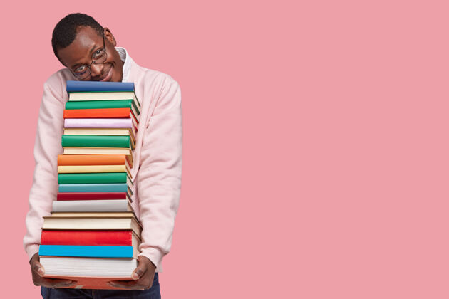 堆栈喜黑皮肤的时髦学生倚在一堆厚厚的书上 穿着休闲毛衣书呆子青少年民族