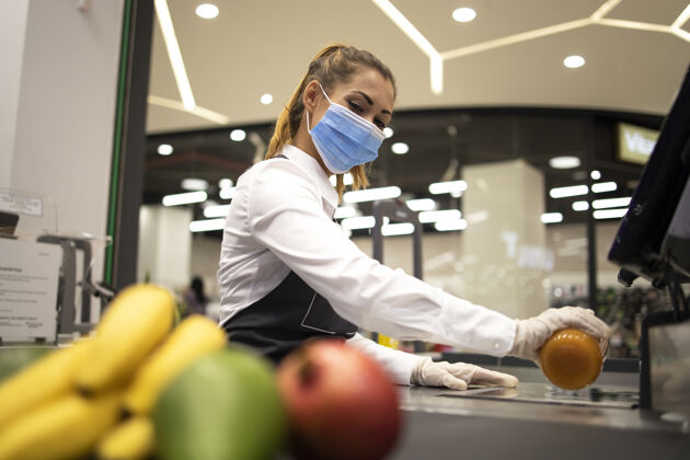 健康超市女收银员戴卫生防护口罩和手套从事电晕病毒大流行的危险工作穿戴防护口罩预防