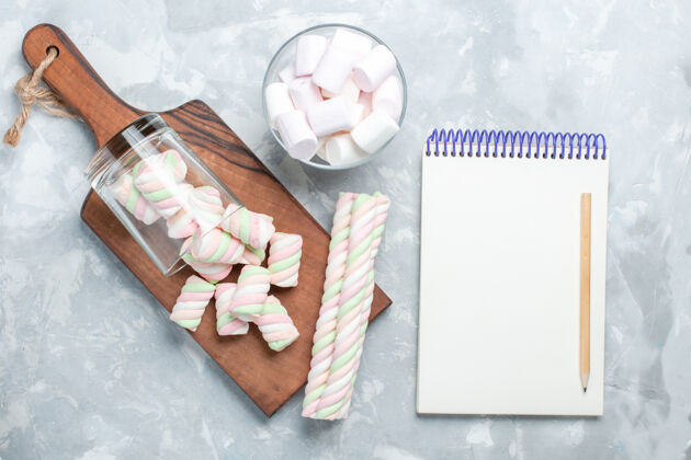 浅白色的顶视图彩色美味的棉花糖小糖果形成浅白色的办公桌上糖的顶部的少量的