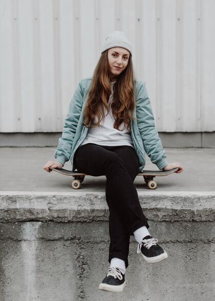 滑板城市里的溜冰女孩坐在溜冰板上生活日光城市