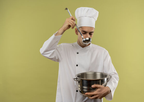穿着年轻的男厨师穿着厨师制服拿着平底锅试着用复印空间喝汤试着制服厨师