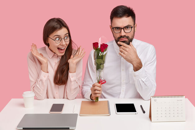 男性浪漫的工作理念快乐的女秘书很高兴收到老板的花束 是情人 坐在桌面上与现代电子设备约会坐着内容