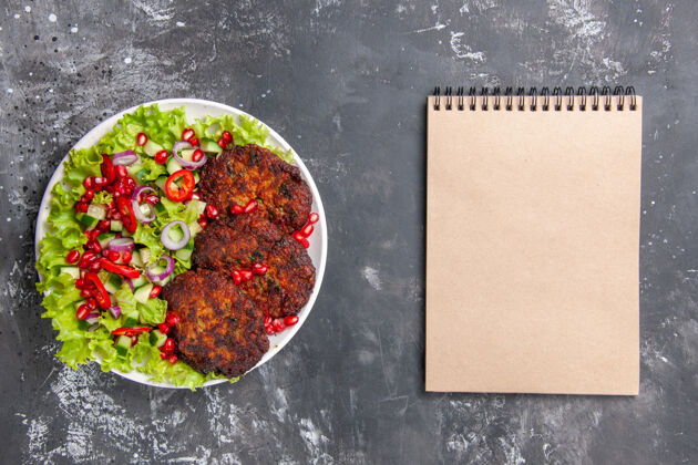 餐厅顶视图美味肉排与新鲜沙拉的灰色背景照片肉菜美味的肉片沙拉西红柿