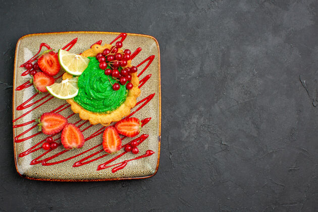 糖果顶视图美味的蛋糕与绿色奶油和草莓在黑暗的背景甜甜点茶赌场甜点王牌