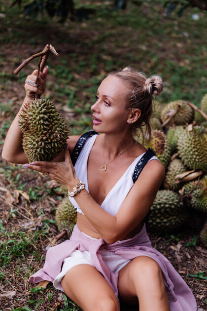 水果热带田野上的年轻时尚女士 带着榴莲水果性感户外自由