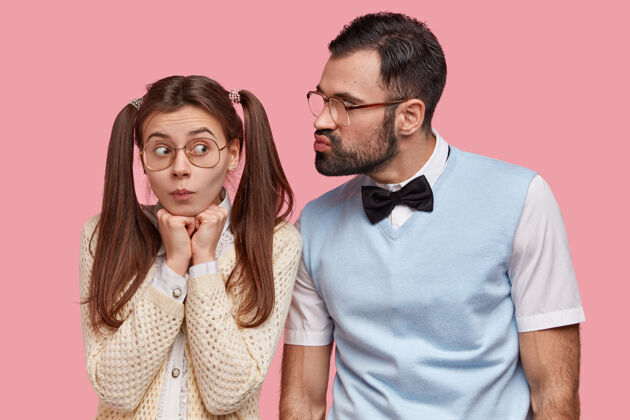 尴尬有趣的女书呆子有两个马尾辫 戴着大眼镜 要接受男朋友的吻 有第一次约会准备书呆子学生