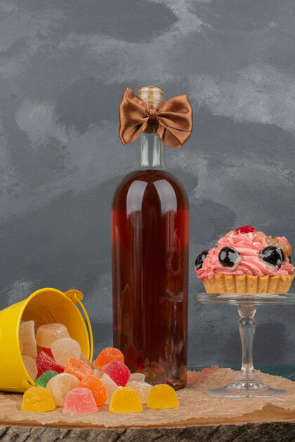 吃一个装着玻璃盘的甜甜圈和果冻糖的瓶子放在木板上果冻盘子食物