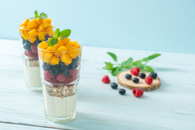 素食主义者自制芒果 覆盆子和蓝莓酸奶和格兰诺拉麦片-健康的食物风格格兰诺拉麦片食物燕麦粥