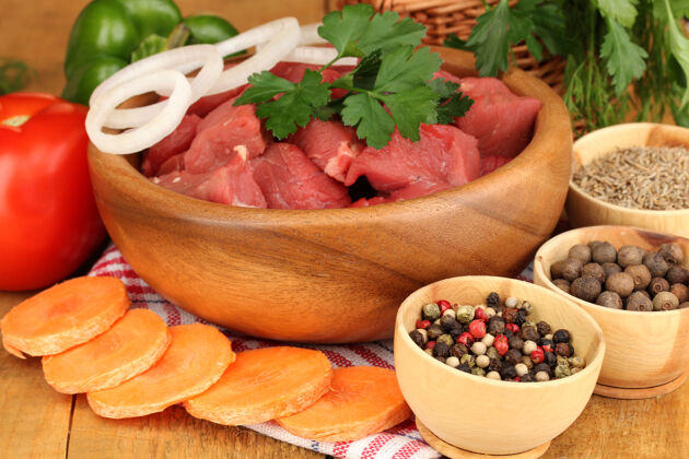 草药用香草和香料腌制的生牛肉放在棕色的木桌上切盐菜
