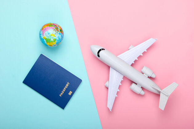 计划旅游和旅游概念地球仪 护照和客机雕像上粉蓝色粉彩墙顶视图平躺游客旅行护照