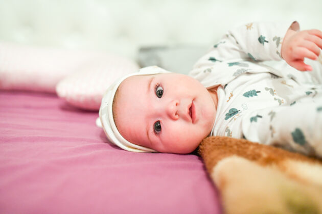 积极家里戴帽子的婴儿可爱的婴儿戴着帽子在床上玩欢笑新生儿快乐
