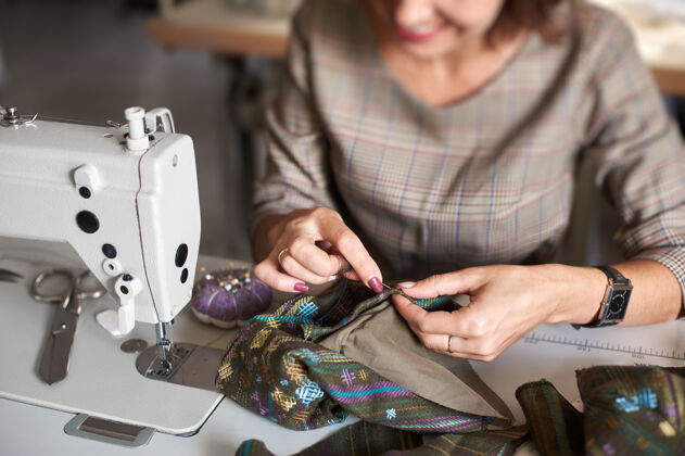设计师手用针把衣服的细节缝在一起再缝机器爱好职业