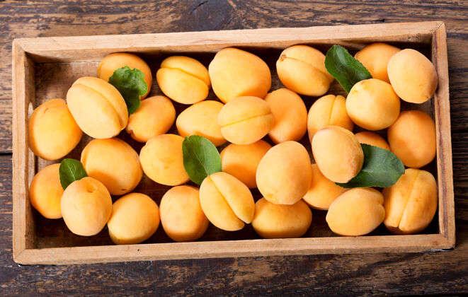 水果新鲜的杏子放在木桌上的盒子里木材成熟的黄色