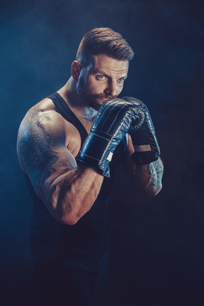 男子气概拳击手在黑墙上和影子搏斗复制空间拳击运动理念成年击强壮