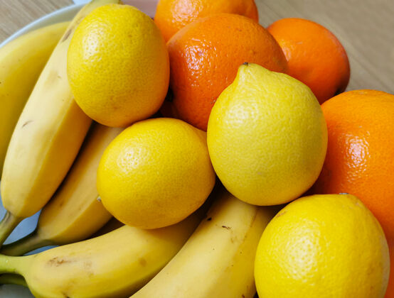 农业摆放在木桌上的五颜六色的新鲜水果配料是香蕉 桔子和柠檬市场新鲜水果一致性