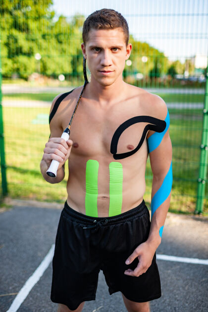 身体帅气的年轻白种人职业网球运动员的肖像 身上带着松紧带 背着球拍围栏男性康复