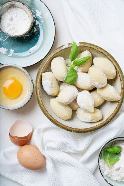 顶视图传统的意大利土豆面食 用罗勒叶 鸡蛋 面粉装饰生面概念顶视图平躺正宗罗勒意大利面食