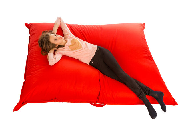 快乐梦中女孩躺在红色的豆包沙发上为客厅或其他房间隔离在白色坐着沙发女人