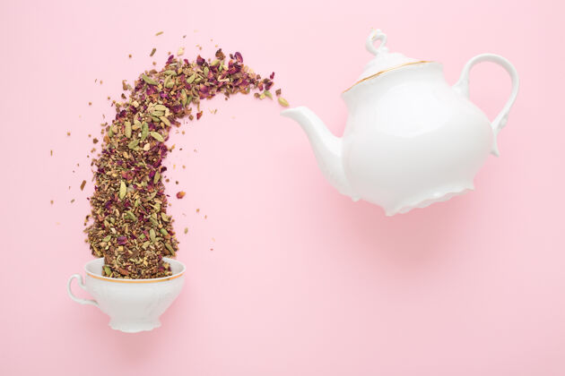 经典干凉茶从白瓷茶壶倒进粉红色的杯子里平铺茶点时间概念花茶新鲜