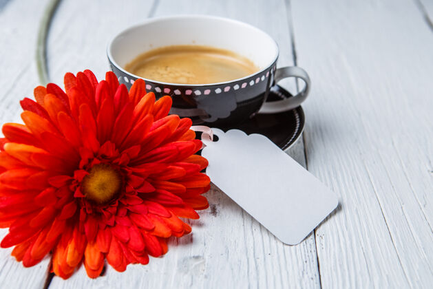 自助餐厅红花 一杯咖啡 放在白桌子上 用干净的卡片摩卡咖啡文字咖啡