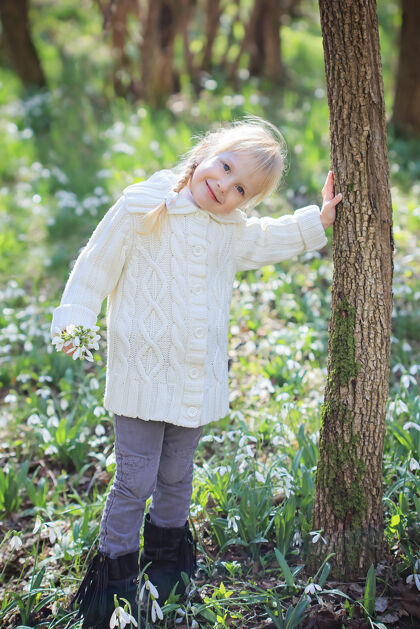 天阳光明媚的春天森林里美丽的小女孩一片雪地复活节时间幼儿园女孩花