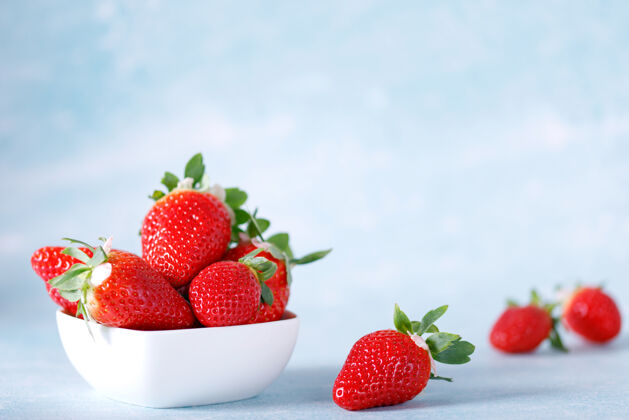 草莓生的红色有机草莓在蓝色的背景上一串成熟水果有机
