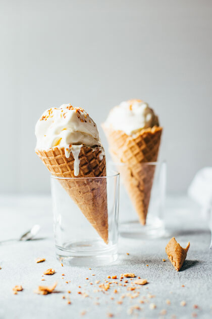 勺子两个白色冰淇淋在华夫饼杯在灰色背景的特写镜头冰淇淋杯杯子冰淇淋