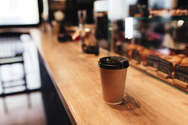 桌子咖啡馆吧台上的纸咖啡杯棕色装饰咖啡