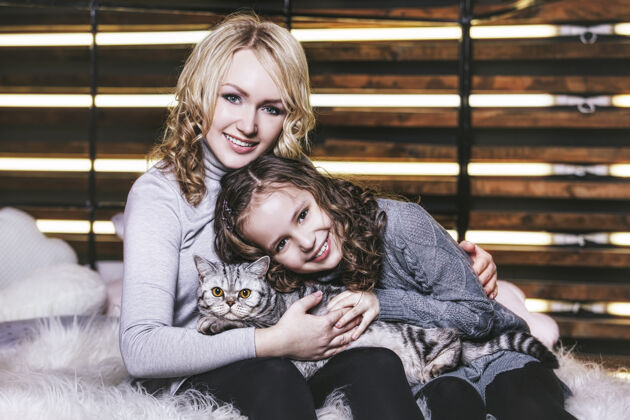 头发时尚可爱的小女孩和美女抱着一只英国小猫在一起很开心猫姐姐童年