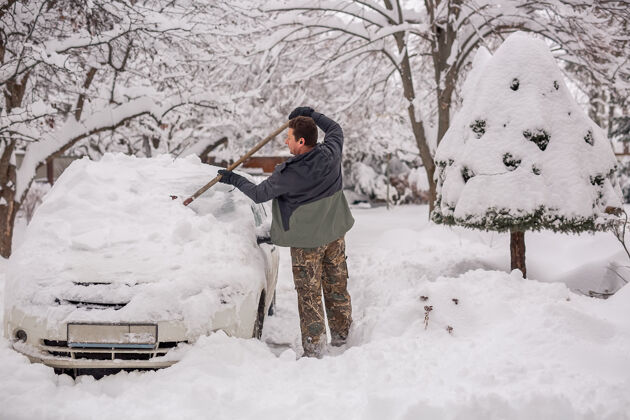 汽车冬天街上的人在清除车上的雪运输户外移除