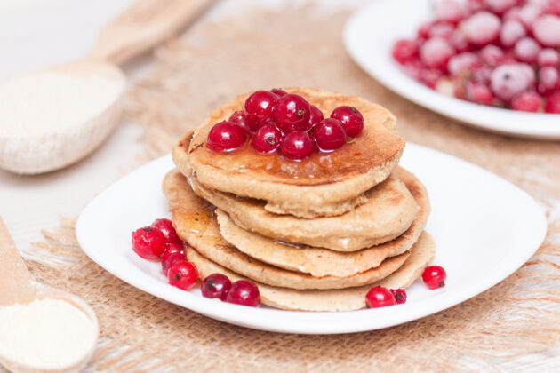 新鲜健康早餐概念面筋免费的玉米和燕麦粉煎饼葡萄干面粉枫树