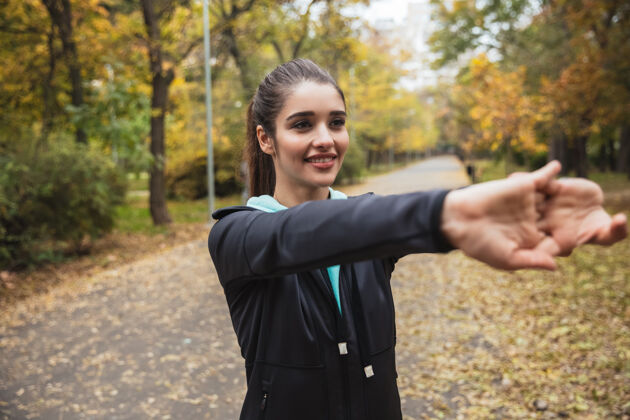 跑步微笑的年轻健身女孩在公园锻炼身体公园活跃运动