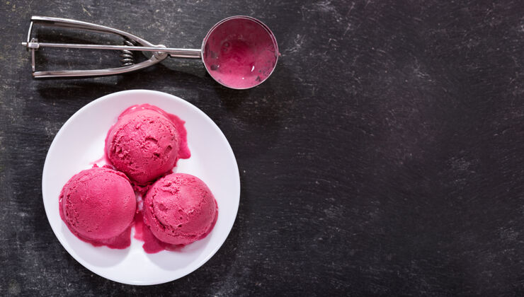蛋卷一盘蓝莓冰淇淋舀在深色背景上奶油冰淇淋蓝莓