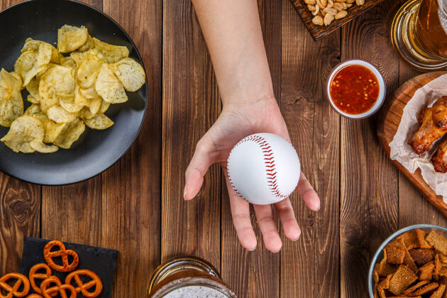 桌子照片上桌上摆着零食 手上拿着棒球板风扇薯条