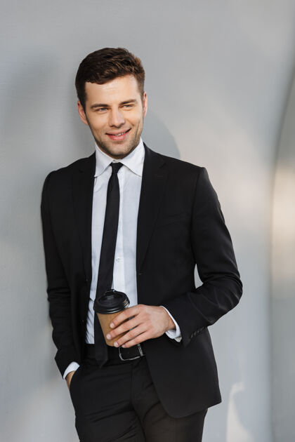 帅哥穿着正装的年轻帅哥商人在街上喝咖啡的照片成人企业家成功