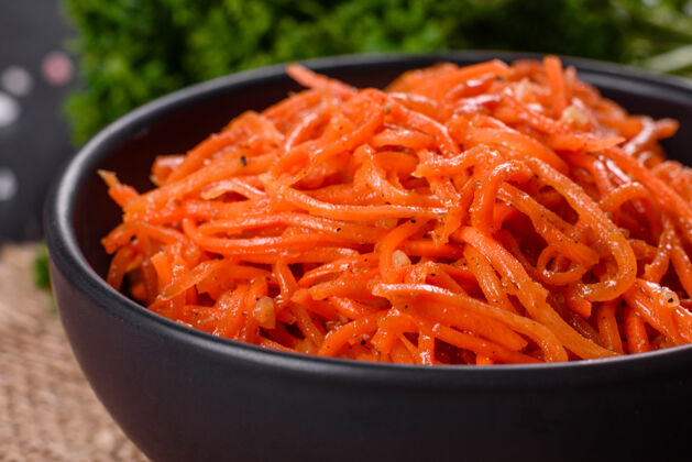 感激美味 辛辣 多汁 明亮的韩国胡萝卜 放在深色水泥上的陶瓷盘子里背景.亚洲人美食烹饪午餐韩国人