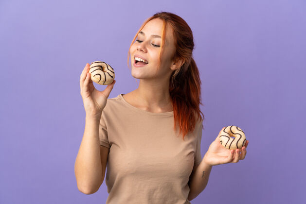 圆形一个孤立的俄罗斯女人拿着甜甜圈 脸上洋溢着幸福的表情卡路里红发不健康
