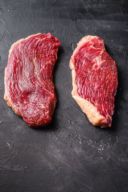 生的有机生皮卡尼亚牛排 在黑色纹理的桌子上 侧视图配料肉牛肉