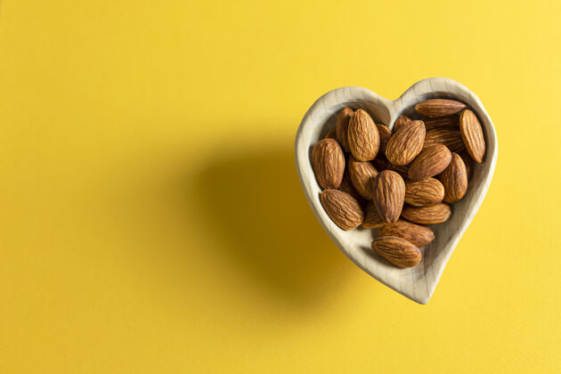 心脏杏仁在一个心形的小木盘里有机坚果食物