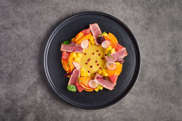芒果金枪鱼牛排沙拉 芒果酱 香草和香料在一个黑暗的盘子 顶视图 复制空间 食品装饰的概念光烤健康