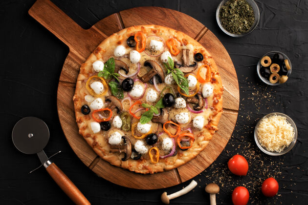 罗勒比萨配马苏里拉 橄榄和蘑菇意大利菜在黑色背景上做比萨饼的原料顶部视图.概念为餐馆做广告烹饪叶子美味