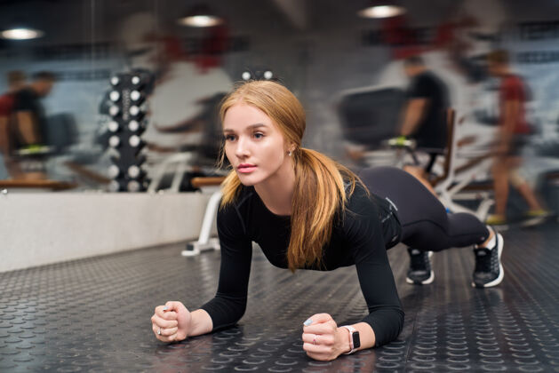 锻炼年轻健康的女人在现代健身房做平板运动活跃身体胸罩