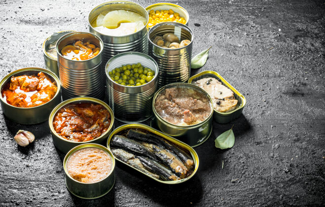 锡各种开罐的罐头食品放在黑色的乡村餐桌上容器厨房保存