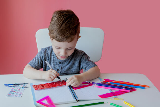 数学可爱的小男孩在家里做的画像家庭作业很少在室内用彩色铅笔集中孩子的注意力写作好奇学前班房子