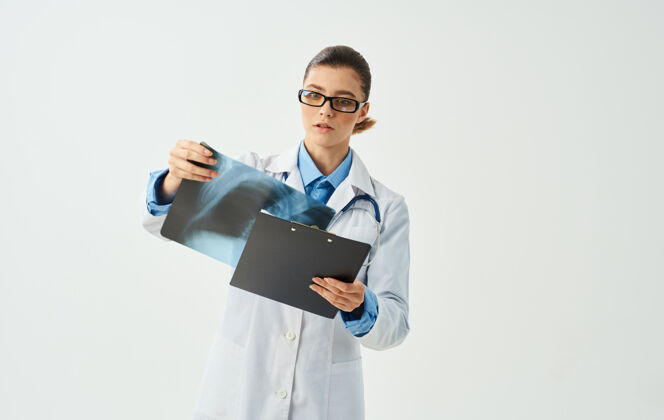 X射线女医生正在检查胸部x光片 背景为浅色裁剪视图护理护士专业知识