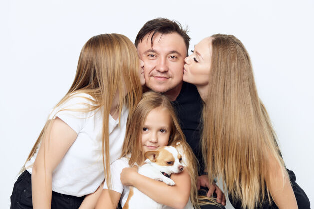 丈夫妈妈抱着女儿亲吻抱着狗的爸爸女孩父母可爱女人