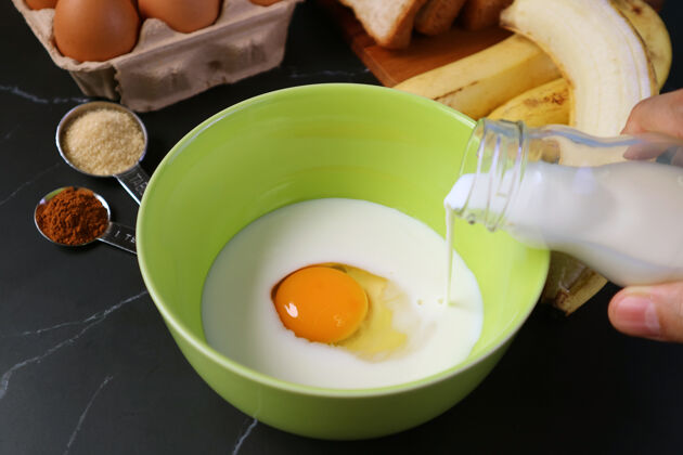 鸡蛋用鲜奶倒在搅拌碗里的生鸡蛋 用来烤香蕉面包布丁美味手指成熟